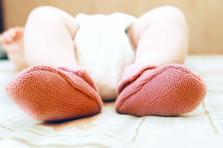 close up of baby's feet in pink socksの写真素材