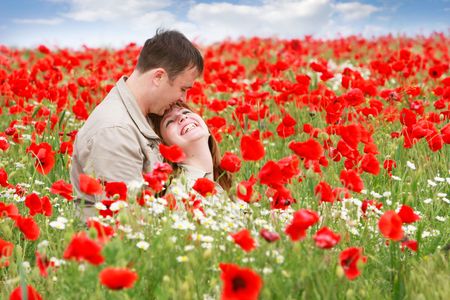 young loving couple on red poppies fieldの写真素材
