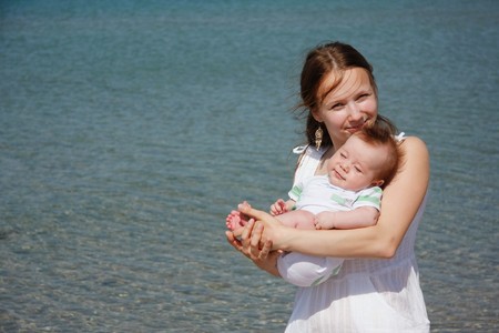 young mother and baby on sea backgroundの写真素材