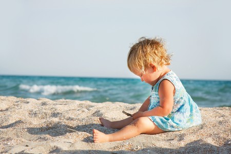 cute toddler girl playing on beachの写真素材