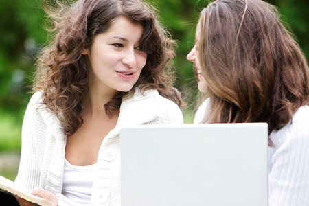 two student girls with laptop on natural backgroundの写真素材
