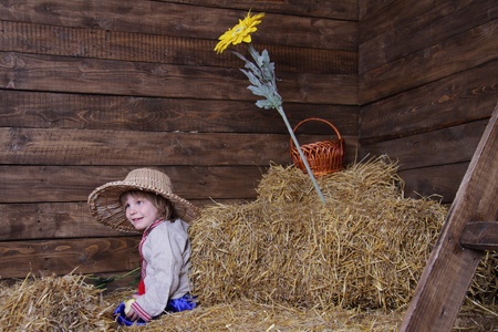 young happy child in traditional eastern european clothes on hayloftの写真素材