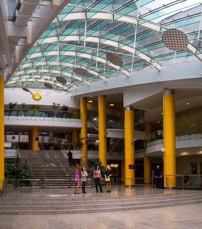 Minsk, Belarus - March 9, 2016: National Library of Belarus modern interior view. Beautiful girls (labrary staff) are waiting for visitors.のeditorial素材