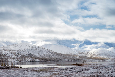 Russia. Magadan Region. Beautiful Lake Momontay against the backdrop of a snowy mountain range. Late autumn in the vicinity of Lake Momontay.の写真素材