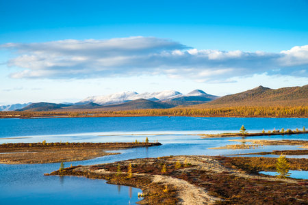 Russia. Magadan Region. Beautiful Lake Momontay against the backdrop of a snowy mountain range. Late autumn in the vicinity of Lake Momontay.の写真素材
