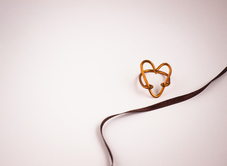 Heart shaped ring near ribbon closeupの写真素材