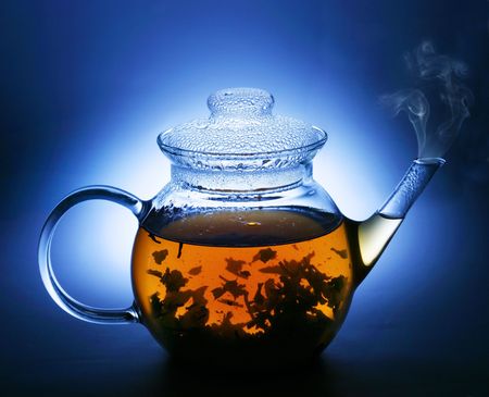 Teapot with tea on a dark blue background.の写真素材