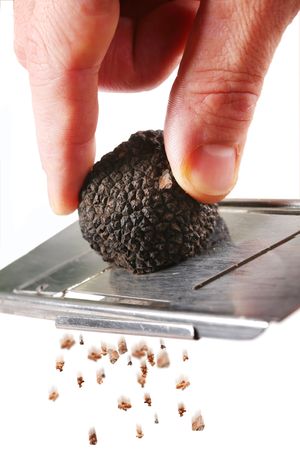 the mushroom of truffle is ground on a grater on a white backgroundの写真素材