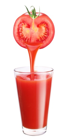 Juice flowing from tomato into the glass.の写真素材