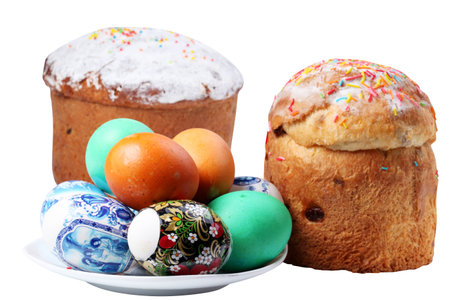 Multi-colored eggs on a plate and cakes. Easter holiday. Isolated on a white