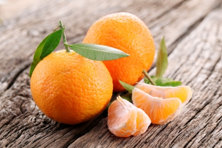 Tangerines with leaves on a wooden table の写真素材