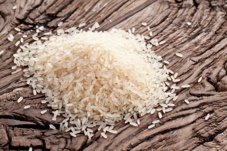 Handful of rice on a wooden table.の写真素材