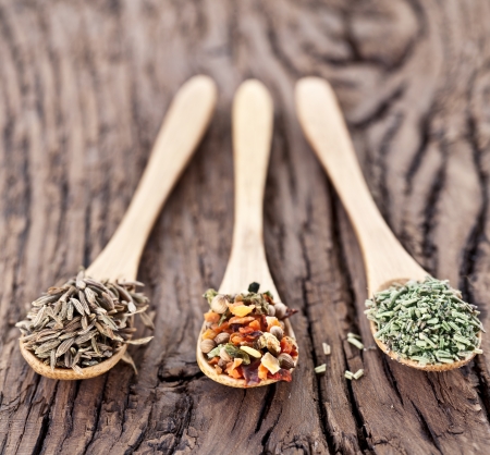 Variety of spices in the spoons on an old wooden table.の写真素材