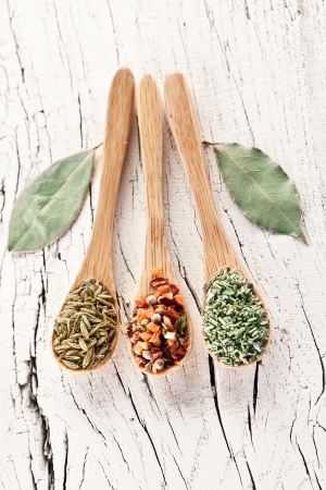 Variety of spices in the spoons on an white old wooden table.の写真素材