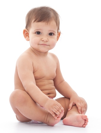 Funny baby sits on the floor isolated on a white background.の写真素材