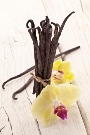 Vanilla sticks with a flower on a white wooden table.の写真素材