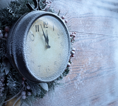 Christmas clock over snow wooden background. Five to twelve.の写真素材