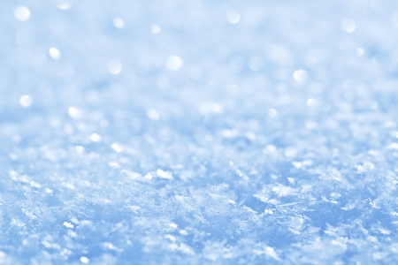Blue sparkling snow background with white little snowflakes.の写真素材