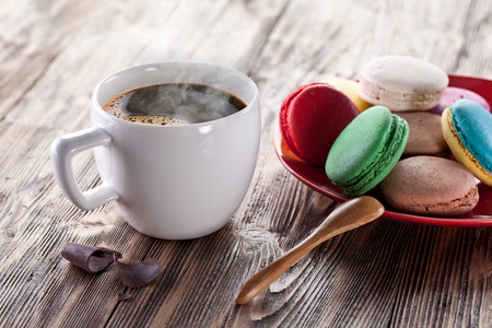 Cup of coffee and french macarons on an old wooden table.の写真素材