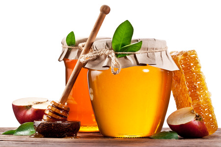 Glass cans full of honey, apples and honeycombs on wood. Clipping paths.の写真素材