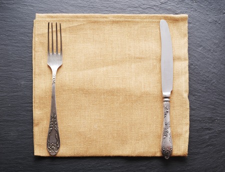 Silver cutlery on a dark grey background.の写真素材