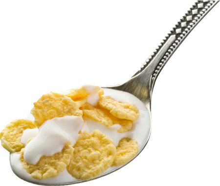 Cornflakes in the silver spoon on white background. File contains clipping paths.