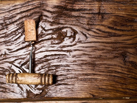 Corkscrew and corks on an old wooden table.の写真素材