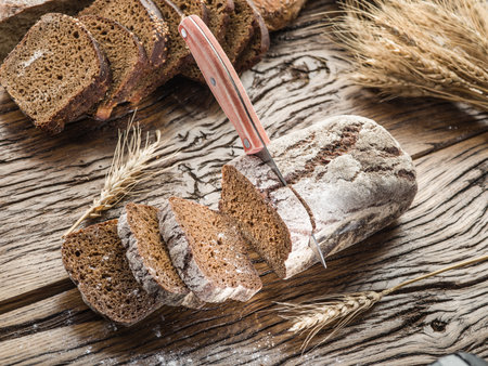 Sliced black bread on the old wooden plank.