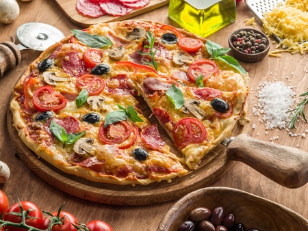 Pizza with mushrooms, salami and tomatoes. Top view.の写真素材