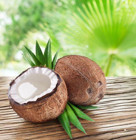 Coconuts on the wooden table with nature on the background.の写真素材