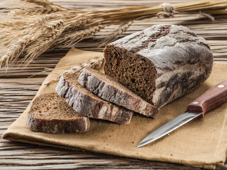 Sliced black bread on the old wooden plank.