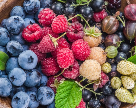Ripe berries in the wooden bowl.の写真素材