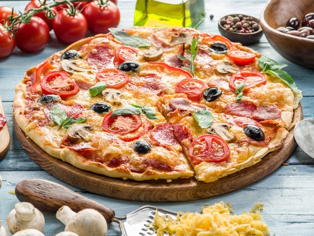 Pizza with mushrooms, salami and tomatoes. Top view.の写真素材