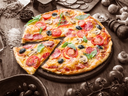 Pizza with mushrooms, salami and tomatoes. Top view.の写真素材