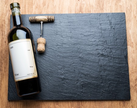 Wine bottle and corkscrew on the graphite board.の写真素材