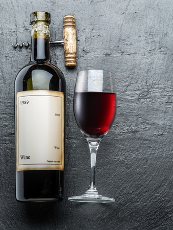 Wine bottle, wine glass and corkscrew on the graphite board.の写真素材