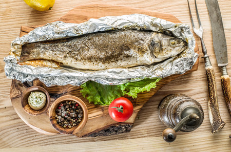 Grilled sea bass fish on the wooden tray.