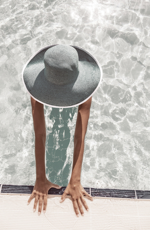 Woman in sun hat in the swimming pool. Top view. Vintage style.の写真素材