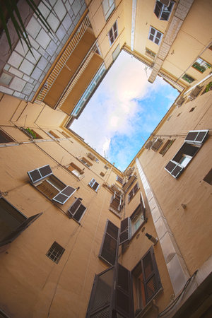 The patch of sky between old houses in the italian patio. Bottom view.