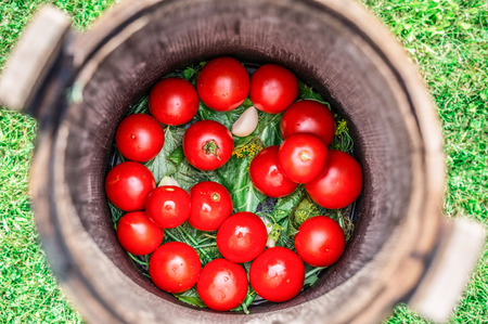 Pickled tomatoes with herbs in the wooden cask.の写真素材