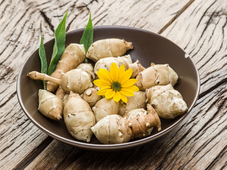 Jerusalem artichoke on wooden table.