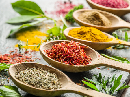 Assortment of colorful spices in the wooden spoons.の写真素材