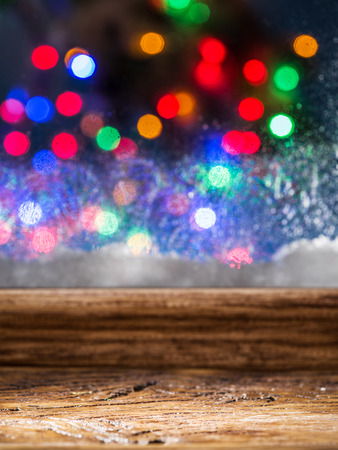 Frozen window with blurred colored lights on the background.の写真素材