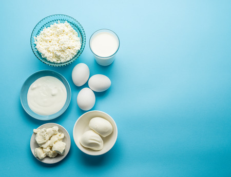 Protein products: cheese, cream, milk, eggs on the blue background. Top view.の写真素材