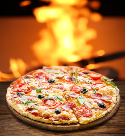 Pizza. Wood-fired oven on the background.の写真素材
