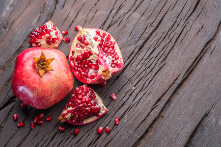 Ripe pomegranate fruits on the wooden background. Top view.の写真素材