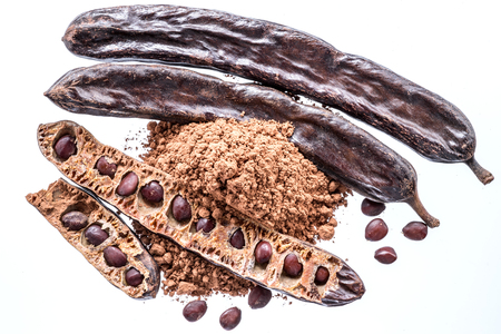 Carob pods and carob powder on the white background.の写真素材