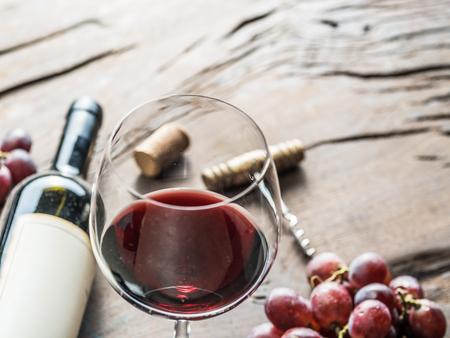 Wine glass, wine bottle and grapes on wooden background.の写真素材
