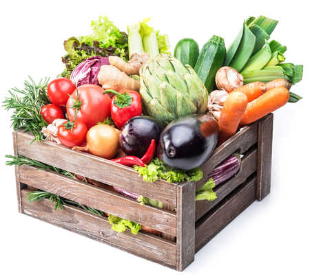 Fresh multi-colored vegetables in wooden crate. White background.の写真素材