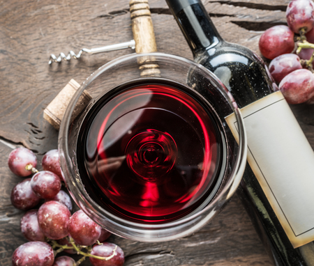 Wine glass, wine bottle and grapes on wooden background. Wine tasting.の写真素材